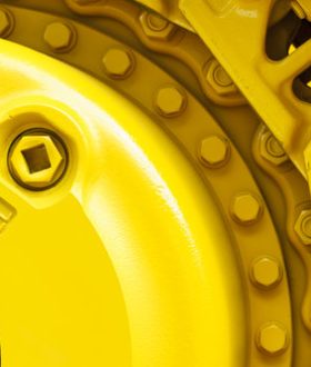 Track drive gear, bulldozer sprocket mechanism, large construction machine with bolts and yellow paint coating, heavy industry, detail